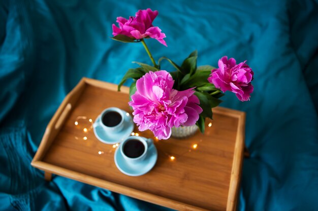 Belles pivoines roses et deux tasses de café