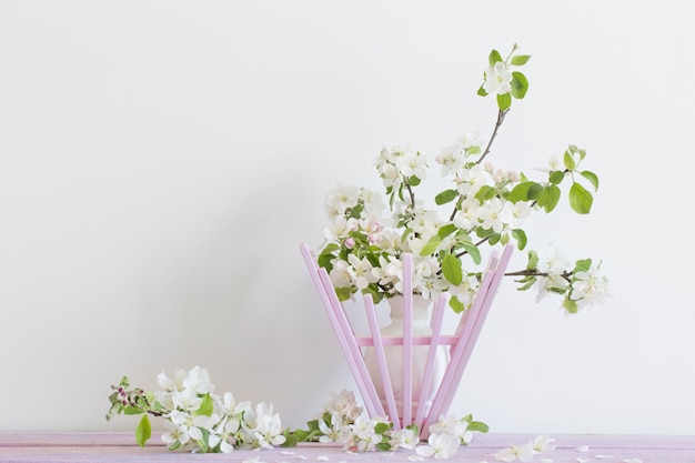 Belles pommes mûres et branches dans un vase sur blanc