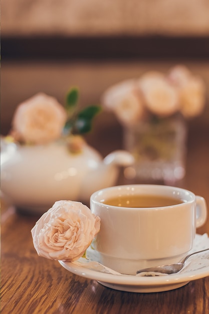 Belles roses fraîches près d'une tasse de thé