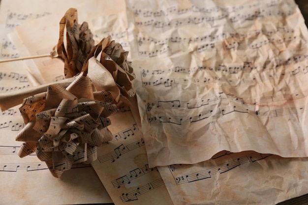 Belles roses en papier sur fond de page de notes de musique