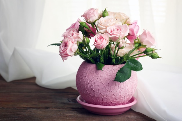 Belles roses en pot sur fond de tissu