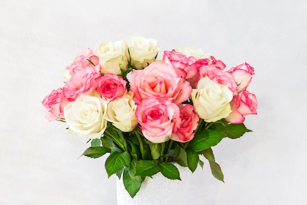 Belles roses roses et blanches dans un vase