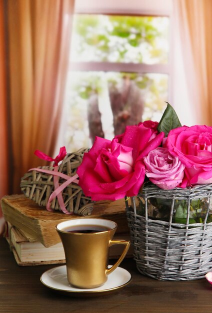 Belles roses roses dans un vase sur une table en bois sur fond de fenêtre