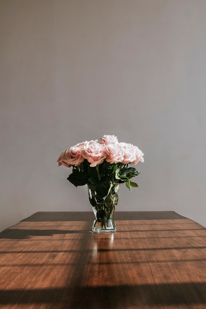 Belles roses roses dans un vase sur une table