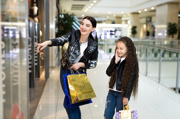 Belles soeurs souriant tout en faisant du shopping au centre commercial