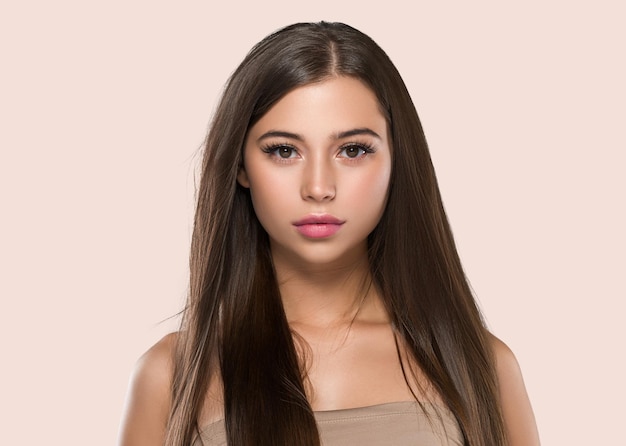 Belles taches de rousseur femme cheveux sains longue coiffure brune lisse fond de couleur rose