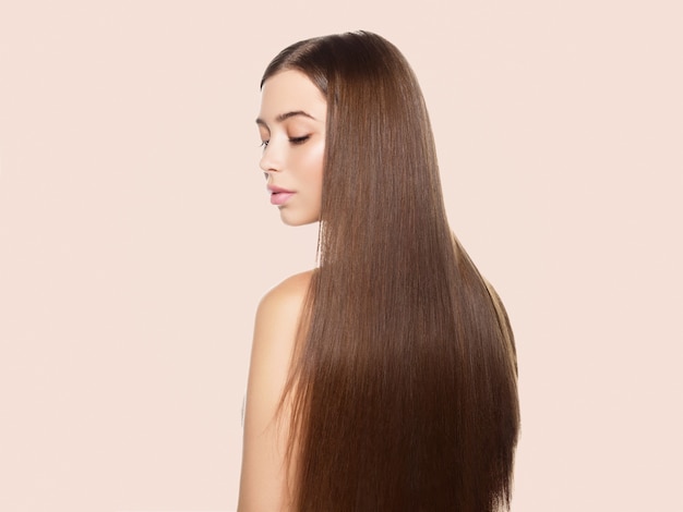 Belles taches de rousseur femme peau saine cheveux longs lisse brunette coiffure concept cosmétique sur beige