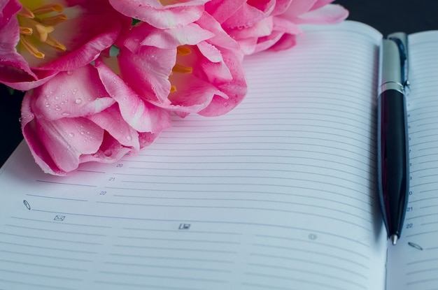 De belles tulipes roses avec un cahier