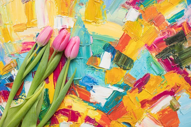 Photo belles tulipes roses sur fond de papier multicolore avec espace de copie. printemps, été, fleurs, concept de couleur, journée de la femme.