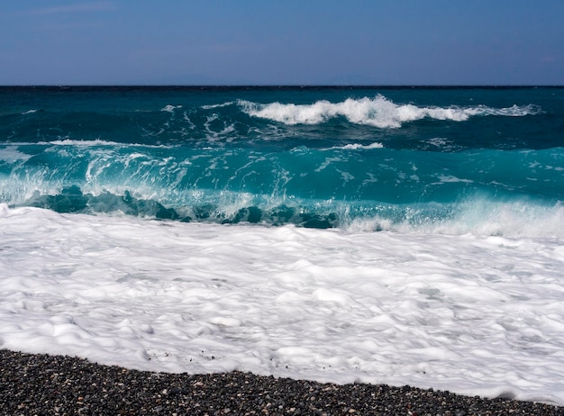 Belles vagues de mousse lors d'une journée ensoleillée dans la mer Égée sur l'île d'Eubée en Grèce