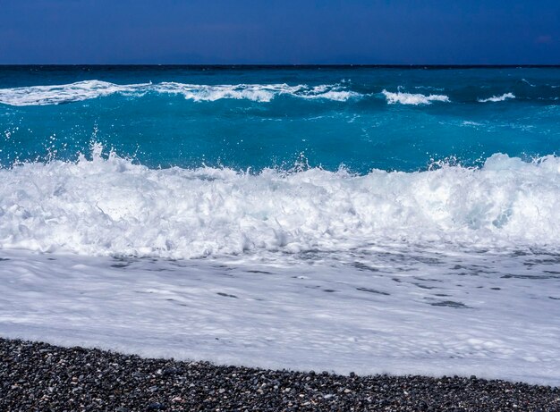 Belles vagues de mousse lors d'une journée ensoleillée dans la mer Égée sur l'île d'Eubée en Grèce