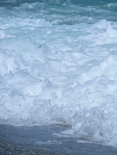 Belles vagues de mousse lors d'une journée ensoleillée dans la mer Égée sur l'île de Grèce