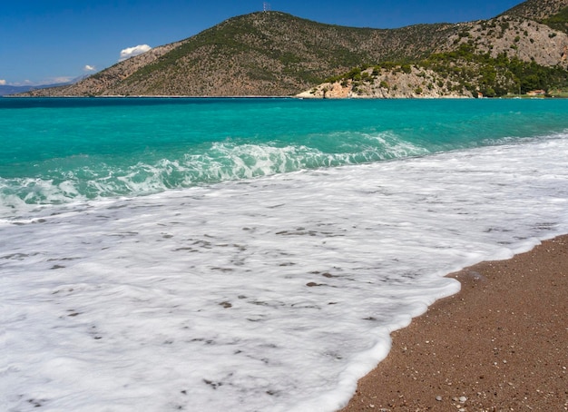 Belles vagues mousseuses sur la plage Psatha dans le golfe de Corinthe et la mer Ionienne en Grèce