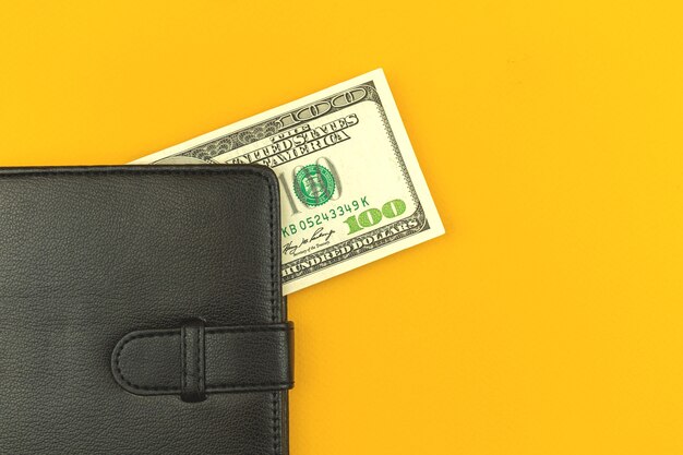 Photo bénéfices et avantages avec le concept d'argent, portefeuille en cuir noir avec cent factures sur le bureau, photo de l'espace de copie