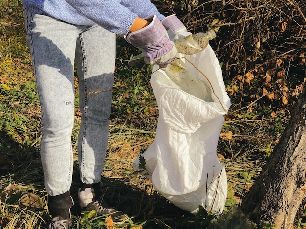 Photo bénévole ramassant des bouteilles en plastique sales dans le parc