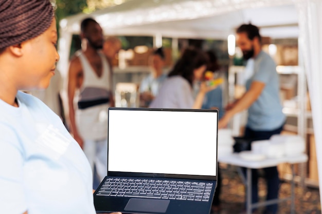 Un bénévole tient un ordinateur portable à écran blanc.