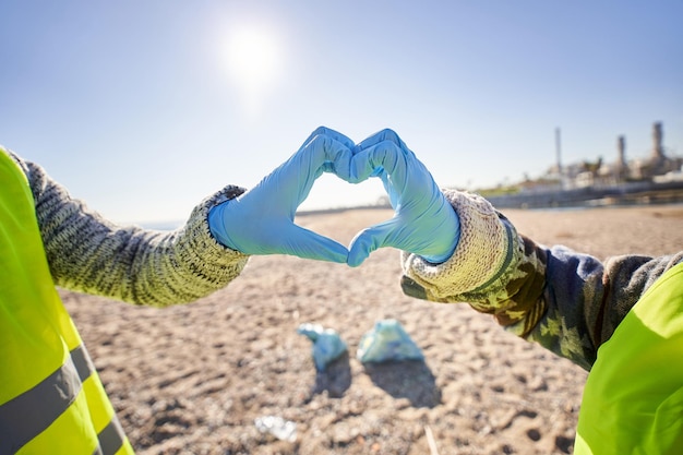 Des bénévoles activistes environnementaux font du cœur avec leurs mains pour protéger la planète Terre.