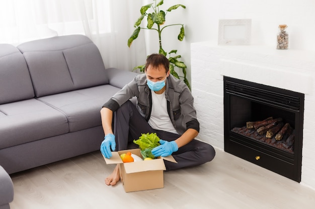 Bénévoles avec boîte de dons avec des denrées alimentaires sur fond gris