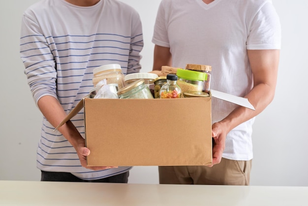 Bénévoles avec boîte de dons avec denrées alimentaires