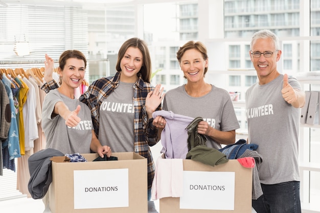 Des bénévoles souriants avec des boîtes de dons