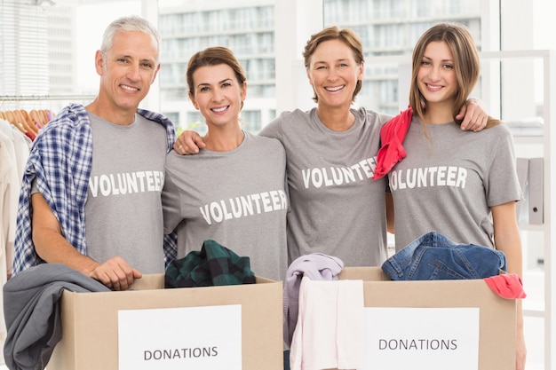 Des bénévoles souriants se serrant les uns les autres