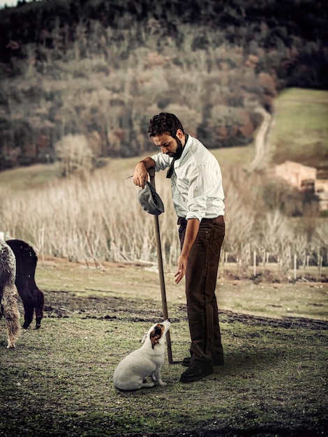 Photo le berger joue avec le chien à la fin d'une journée fatigante.