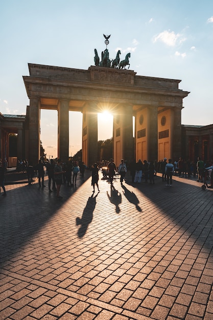 Berlin, porte de Brandebourg avec les touristes en silhouette au coucher du soleil