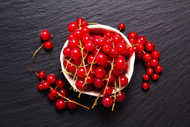 Berry de fruits rouges d&#39;été dans une tasse en céramique sur planche de Pierre ardoise noire avec espace copie