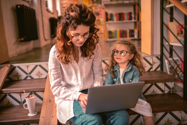 Besoin de votre attention. Gentille fille levant la tête en regardant sa maman