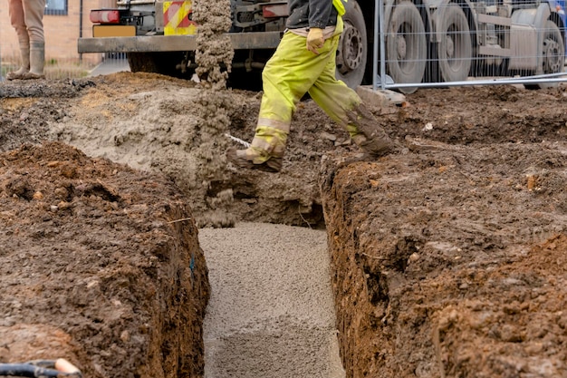 Béton semi-sec prêt à l'emploi livré sur chantier et déchargé du camion malaxeur