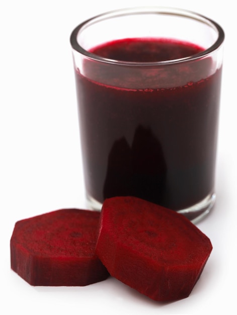 Betteraves rouges avec du jus dans un verre sur fond blanc