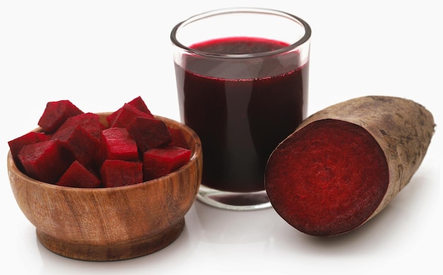 Betteraves rouges avec du jus dans un verre sur fond blanc