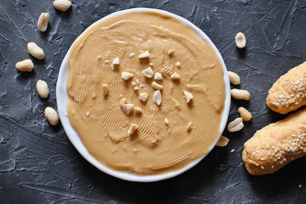 Beurre de cacahuète traditionnel américain avec des cacahuètes salées idées de petit-déjeuner bâtonnets de pain sans gluten avec du beurre de cacahuète pour un menu sain