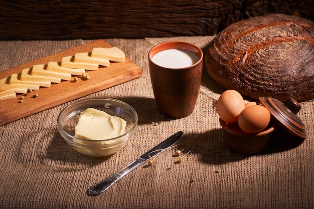 Beurre et fromages et lait pour le petit déjeuner, sur un fond en bois rustique avec espace de copie.