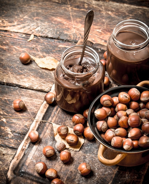 Beurre de noix au chocolat et noisettes sur fond de bois