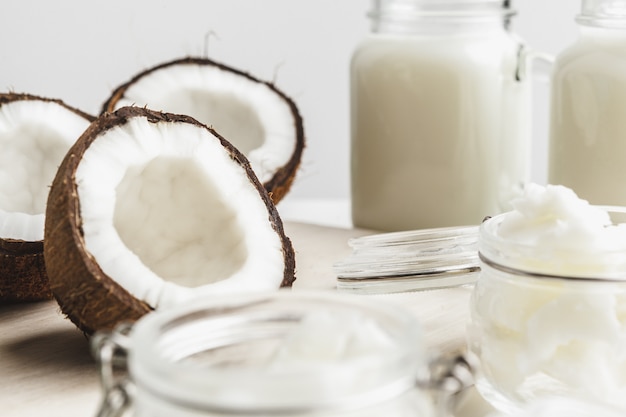 Beurre de noix de coco sain biologique et morceaux de noix de coco fraîche sur une planche de bois