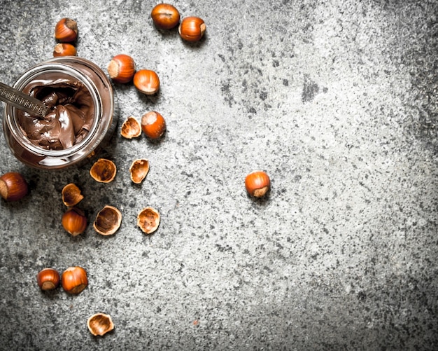 Beurre de noix de noisettes et chocolat sur fond rustique