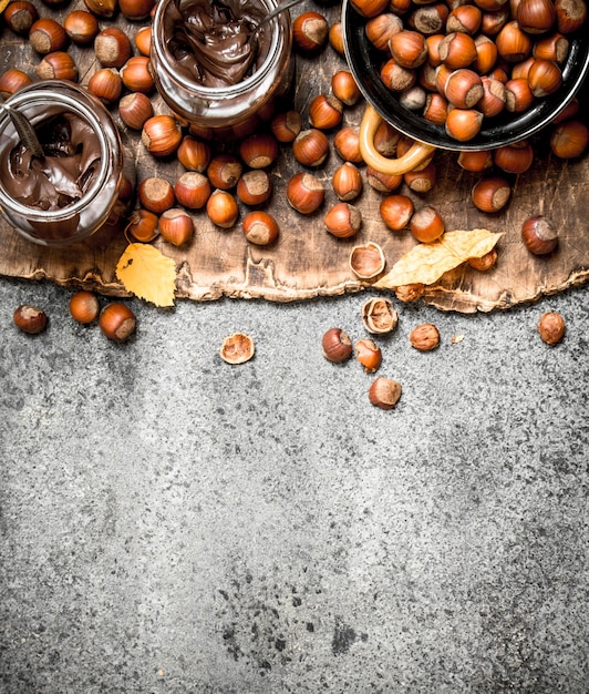 beurre de noix de noisettes et chocolat. Sur fond rustique.