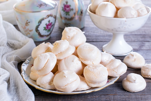 Beze ou Meringues dans un bol sur une table en bois