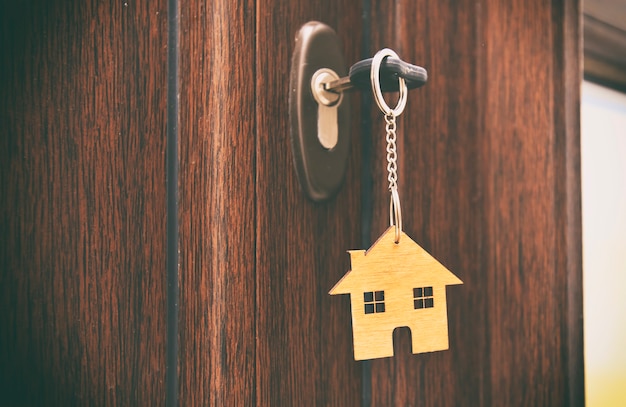 Un bibelot en forme de maison sur la clé dans le trou de la serrure