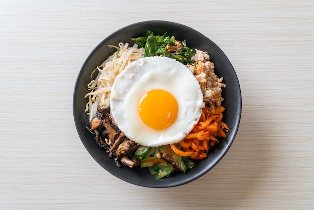Bibimbap, salade épicée coréenne avec riz et œuf frit - style de cuisine traditionnelle coréenne