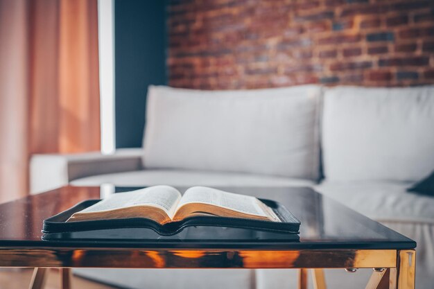 Bible ouverte sur la table dans l'intérieur moderne du salon