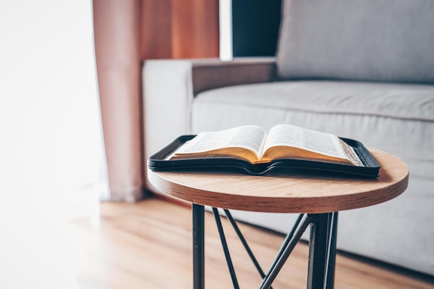 Bible ouverte sur la table dans l'intérieur moderne du salon