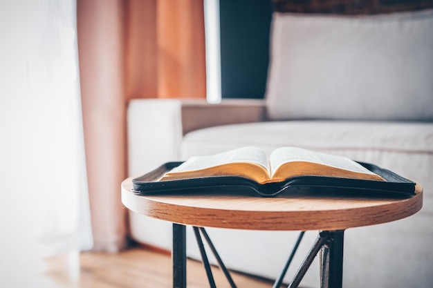 Bible ouverte sur la table dans l'intérieur moderne du salon