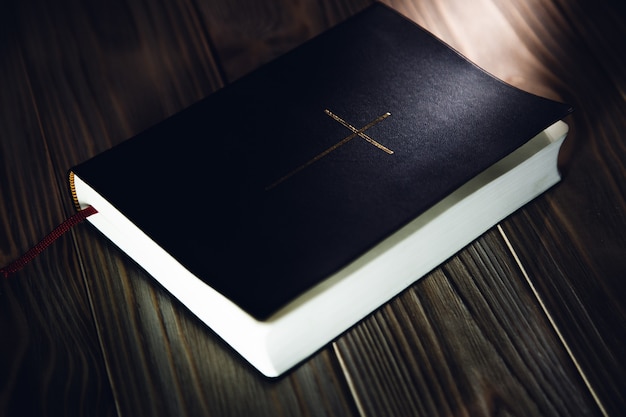 Bible sur une table en bois. Livre avec croix de religion chrétienne