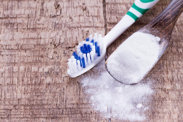 Photo le bicarbonate de soude et la brosse sont la table en bois