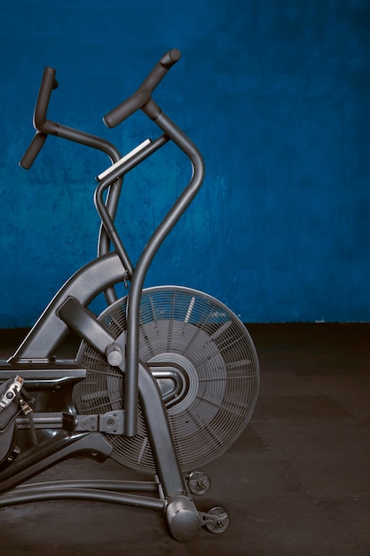 Photo bicicleta de aire en gimnasio con piso de goma y fondo azul