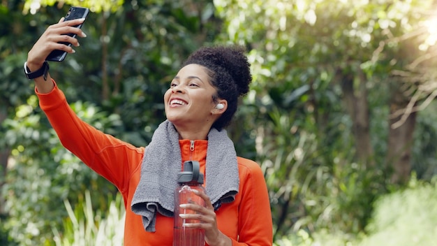 Bien-être santé et selfie par l'influenceur des médias sociaux publicité exercice eau et hydratation Blogueur de fitness enregistrant le contenu du parcours de perte de poids tout en faisant de l'exercice dans un parc ou une forêt