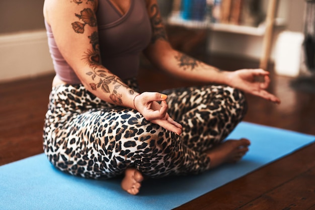 Les bienfaits de la méditation sont répandus Gros plan d'une femme méditant sur un tapis de yoga à la maison