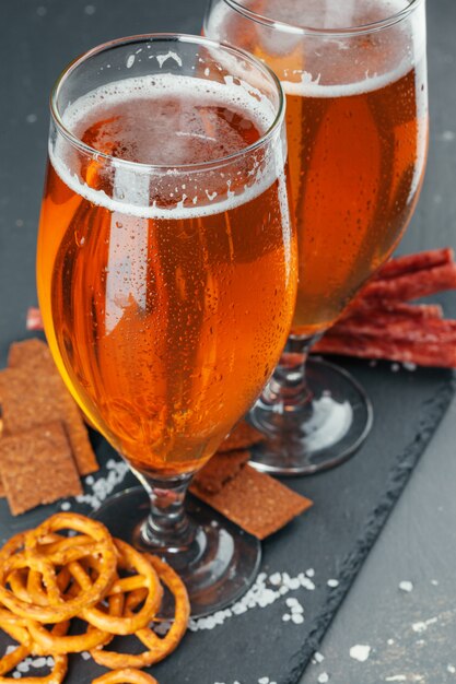 bière et appétissant jeu de snacks à la bière. Table avec chope de bière, planche de bois avec des saucisses